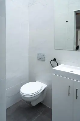 a white bathroom with a toilet and a sink at The One on Pienaar in Cape Town