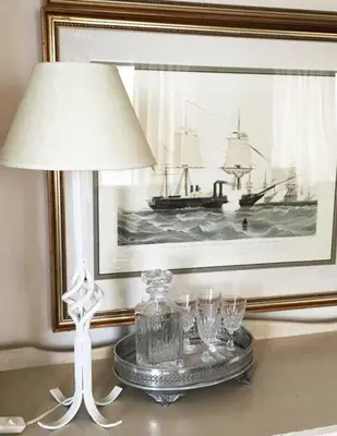 a table with a lamp and a picture of a boat at True coastal living - 2gether on Voëlklip in Hermanus