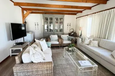 a living room with two couches and a tv at True coastal living - 2gether on Voëlklip in Hermanus