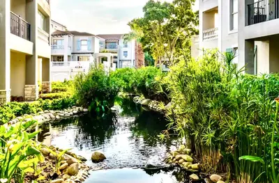 a pond in the middle of a courtyard with buildings at Cozy&warm apartment in Century city in Cape Town