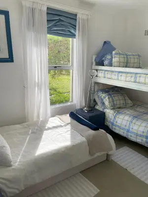 a bedroom with two beds and a window at Oceans Edge - Hermanus Beach Club in Hermanus