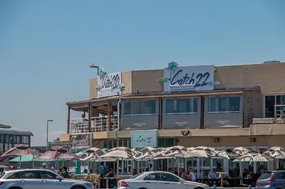a building with umbrellas and cars parked in front of it at Witsand 102 in Bloubergstrand