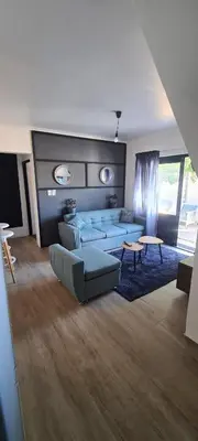 a living room with a couch and a table at Serenity Hideaway in Cape Town