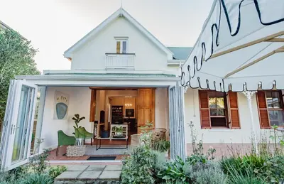 a white house with a porch and a patio at Bonne Esperance Villa in Stellenbosch