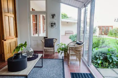 a room with a porch with chairs and a table at Bonne Esperance Villa in Stellenbosch