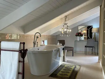 a large bathroom with a large tub in a room at Calais Guest House in Franschhoek