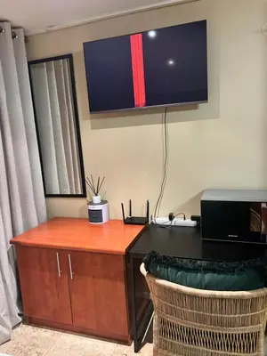 an office with a desk and a tv on the wall at Studio Apartment Paarl Central in Paarl
