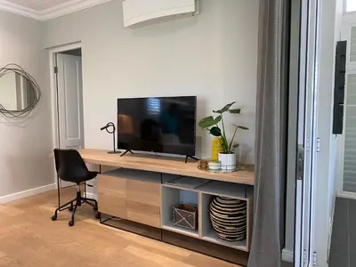 a room with a desk with a television and a chair at The Oak Suite - 7 on Murray Historic Stellenbosch in Stellenbosch