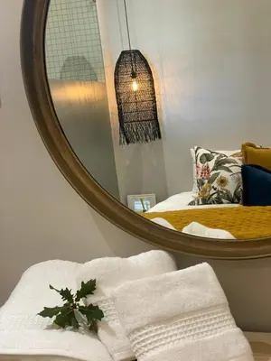 a bedroom with a mirror and a bed with towels at The Oak Suite - 7 on Murray Historic Stellenbosch in Stellenbosch