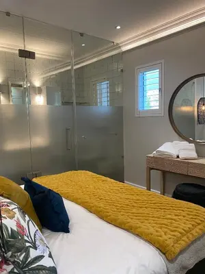 a bedroom with a large bed with a large mirror at The Oak Suite - 7 on Murray Historic Stellenbosch in Stellenbosch