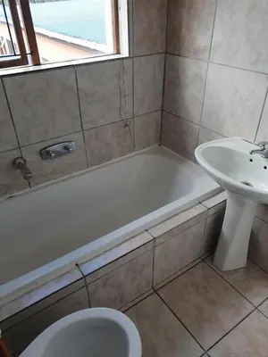 a bathroom with a tub and a sink and a toilet at Ludinz Guest House, Self catering in Cape Town