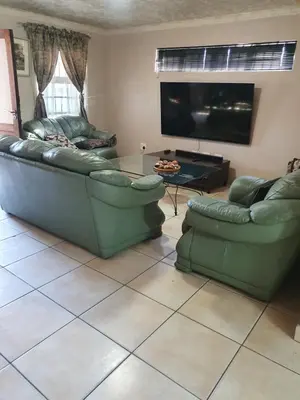 a living room with two couches and a flat screen tv at Ludinz Guest House, Self catering in Cape Town