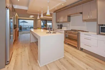 a kitchen with white cabinets and a kitchen island at Waterstone Villa in Hermanus