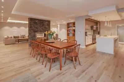 a kitchen and dining room with a wooden table and chairs at Waterstone Villa in Hermanus