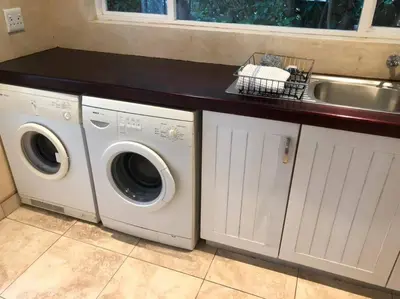 a kitchen with two washing machines and a sink at House in Hermanus Voëlklip in Hermanus