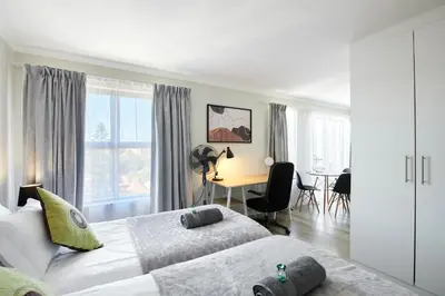 a bedroom with two beds and a desk in it at The Rondebosch Views in Cape Town