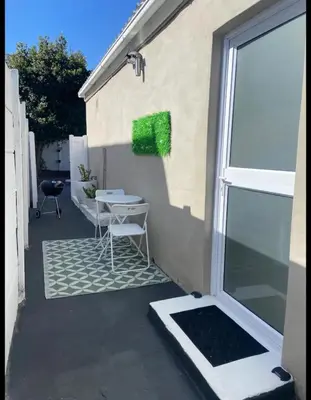 a patio with a table and chairs next to a window at BREATHE On SOUTH in Cape Town