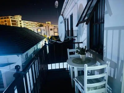 a balcony with a table and chairs on a building at Affordable Guest house in Mwobray in Cape Town