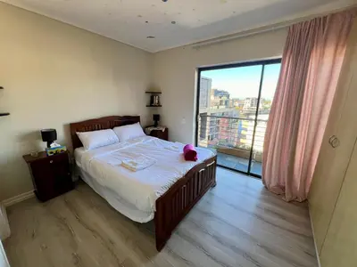 a bedroom with a bed with a teddy bear on it at The Hippo Luxury Apartment in Cape Town