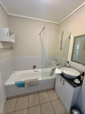 a bathroom with a bath tub and a sink at The Hippo Luxury Apartment in Cape Town