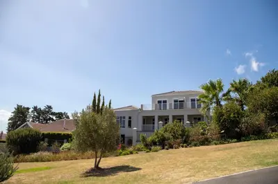 a large white building with a lawn in front of it at House Simon in Somerset West