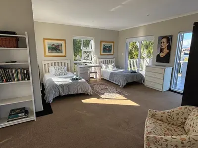 a bedroom with two beds and a desk and a chair at House Simon in Somerset West
