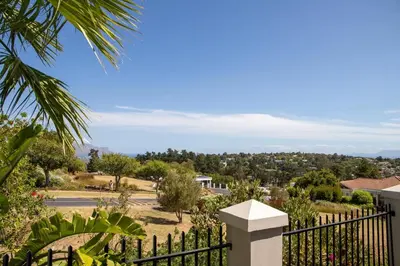 a black fence with a view of a town at House Simon in Somerset West