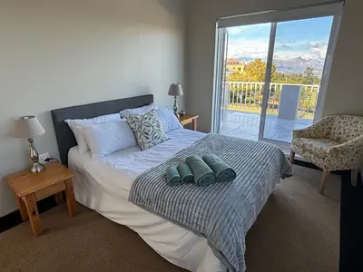 a bedroom with a bed with a view of a balcony at House Simon in Somerset West