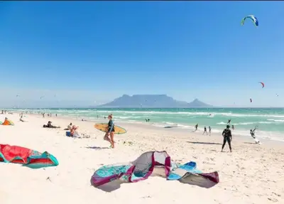 a group of people on a beach with kites at WiFi & Solar at Studio on Morgenster in Cape Town