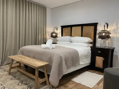 a bedroom with a large bed with white pillows at 29nTanglewood cr, Sunset Links residential Estate in Cape Town