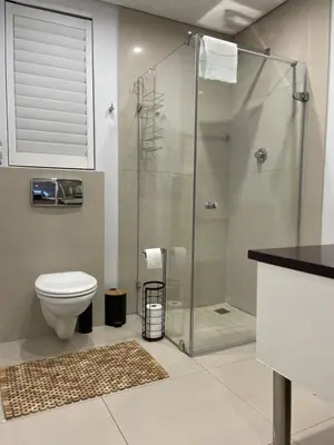 a bathroom with a toilet and a glass shower at 29nTanglewood cr, Sunset Links residential Estate in Cape Town
