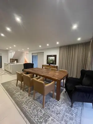 a living room with a wooden table and chairs at 29nTanglewood cr, Sunset Links residential Estate in Cape Town