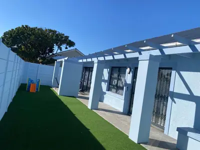 a pergola on a building with a green lawn at 32 On Gill Road Self Catering in Cape Town