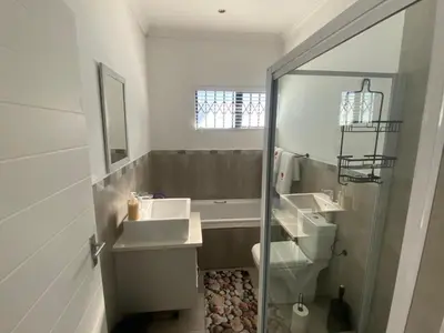 a white bathroom with two sinks and a shower at 32 On Gill Road Self Catering in Cape Town