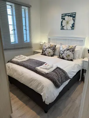 a bedroom with a large bed with towels on it at The Muscadel - Paarl - Self Catering Apartment in Paarl