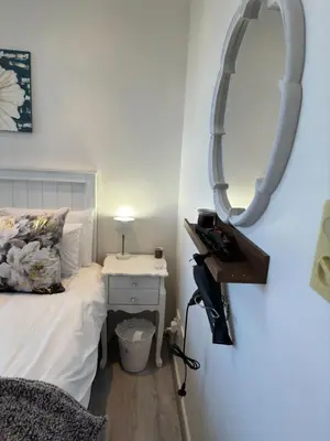 a bedroom with a bed and a mirror on the wall at The Muscadel - Paarl - Self Catering Apartment in Paarl