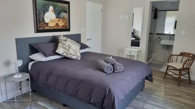 a bedroom with a bed with three pillows on it at Lorenza's Place in Stellenbosch