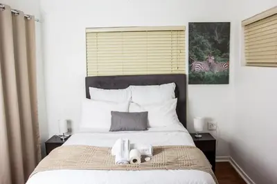 a bedroom with a large bed with towels on it at Botha Villa Lodge Goodwood in Cape Town