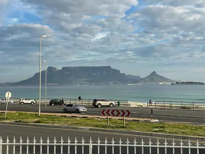 a highway with cars parked on the side of a beach at Blouberg Sea View in Bloubergstrand