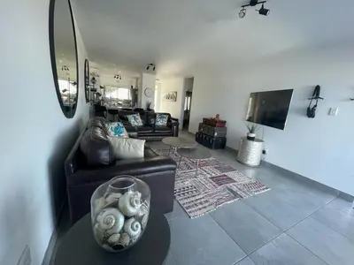 a living room with a couch and a tv at Blouberg Sea View in Bloubergstrand