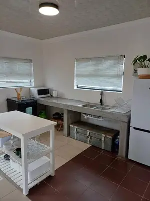a kitchen with a table and a white refrigerator at Lanaria 9, Betty's Bay in Clareport