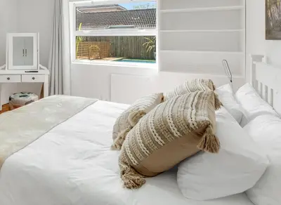 a white bed with white pillows and a window at Kiefern Haus Main House in Cape Town