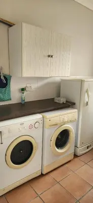 a kitchen with a washing machine and a washer at Picollo Bocca Villa Kleinmond in Kleinmond