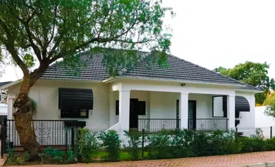 a white house with a black roof at Villa Des Roses in Paarl