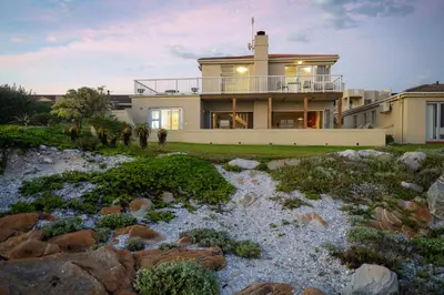 a house with a river in front of it at House 12 Beach Club in Hermanus