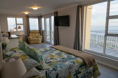a bedroom with a bed and a view of the ocean at House 12 Beach Club in Hermanus