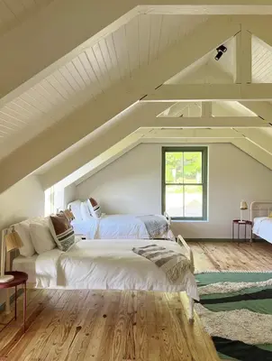 a attic bedroom with two beds and a window at Moya's Vineyard in Mosselrivier