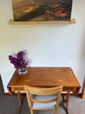 a wooden table with a vase of purple flowers on it at Garden studio close to Wine Farms in Somerset West