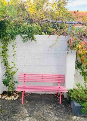 a red bench sitting in front of a wall at Garden studio close to Wine Farms in Somerset West