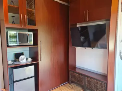 a kitchen with wooden cabinets and a microwave at SharronDeez in Cape Town